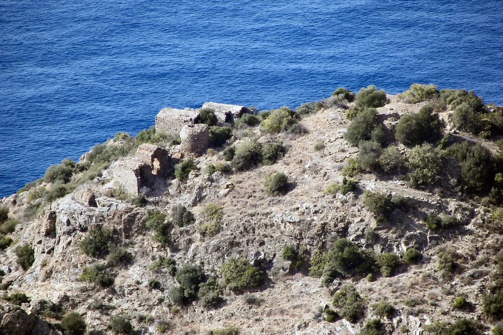 Ruïnes op een rotsige kaap van Antiochia ad Cragum boven de diepblauwe zee