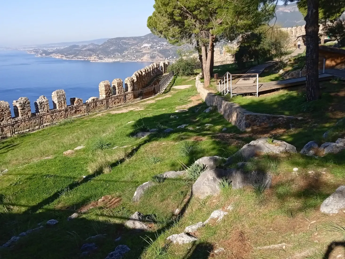 Grasveld en kantelen binnen de İçkale van Alanya met uitzicht over de baai