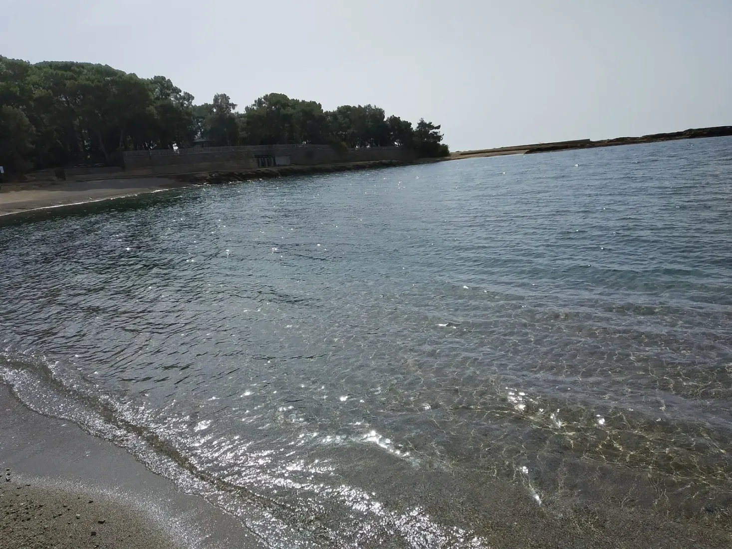 De rustige baai van İncekum met het dennenbos dat tot aan het water loopt
