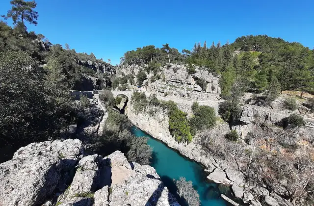 De turquoise Köprü-rivier tussen witte rotsen in de Köprülü Kanyon met de oude stenen brug