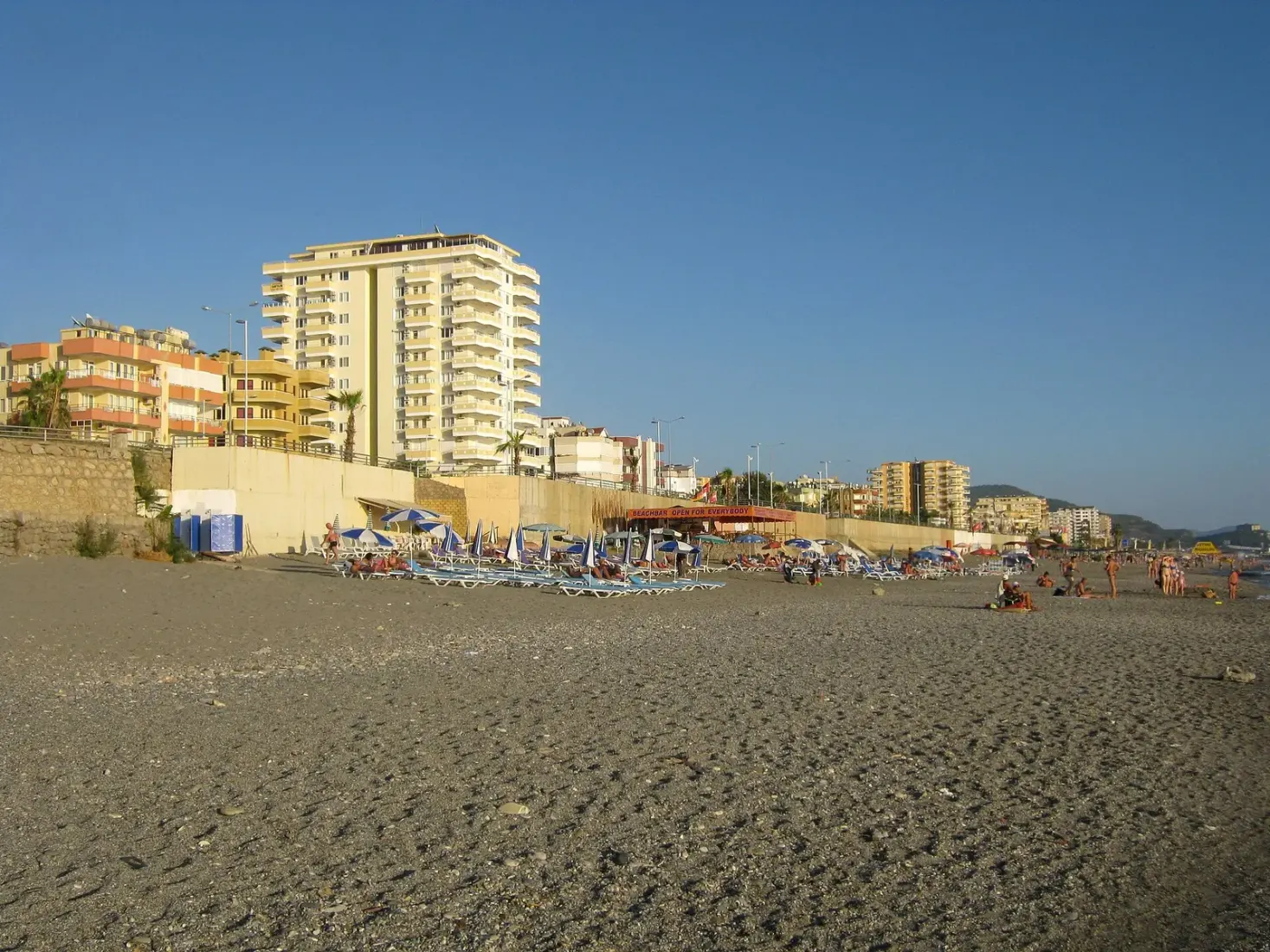 Het brede strand van Mahmutlar met ligbedden en appartementen erachter