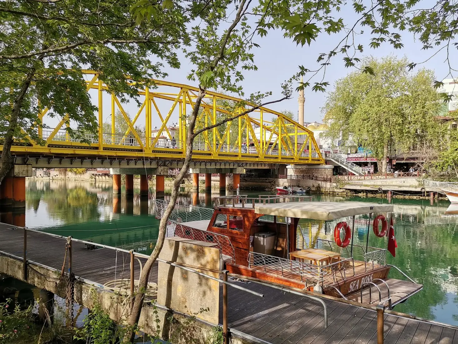 Rondvaartboot aan de steiger bij de gele brug over de Manavgat rivier
