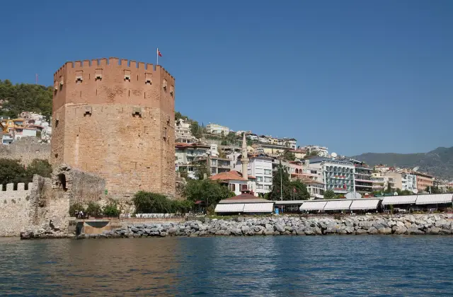 De achthoekige Rode Toren van Alanya aan de waterkant, gezien vanaf zee