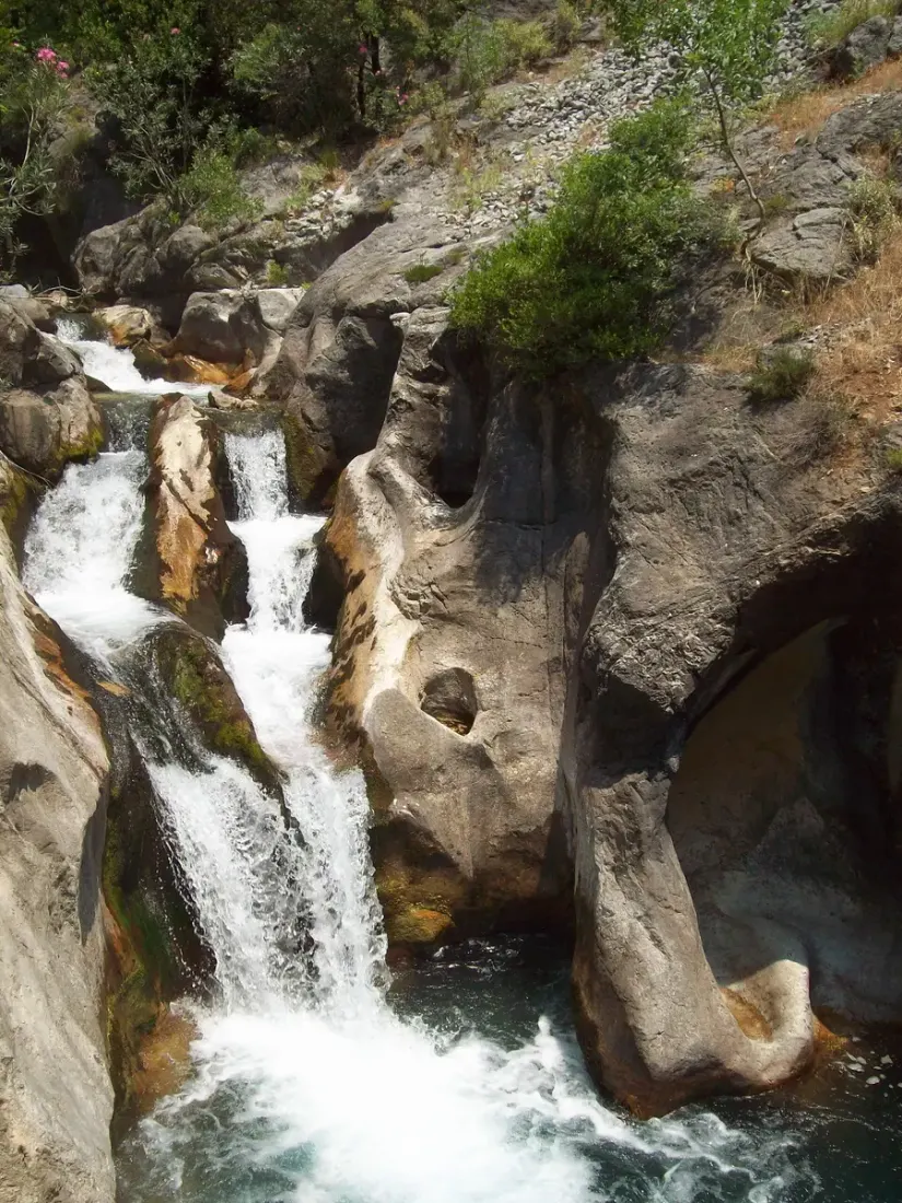 Een waterval die door een smalle rotsgeul van de Sapadere kloof stort