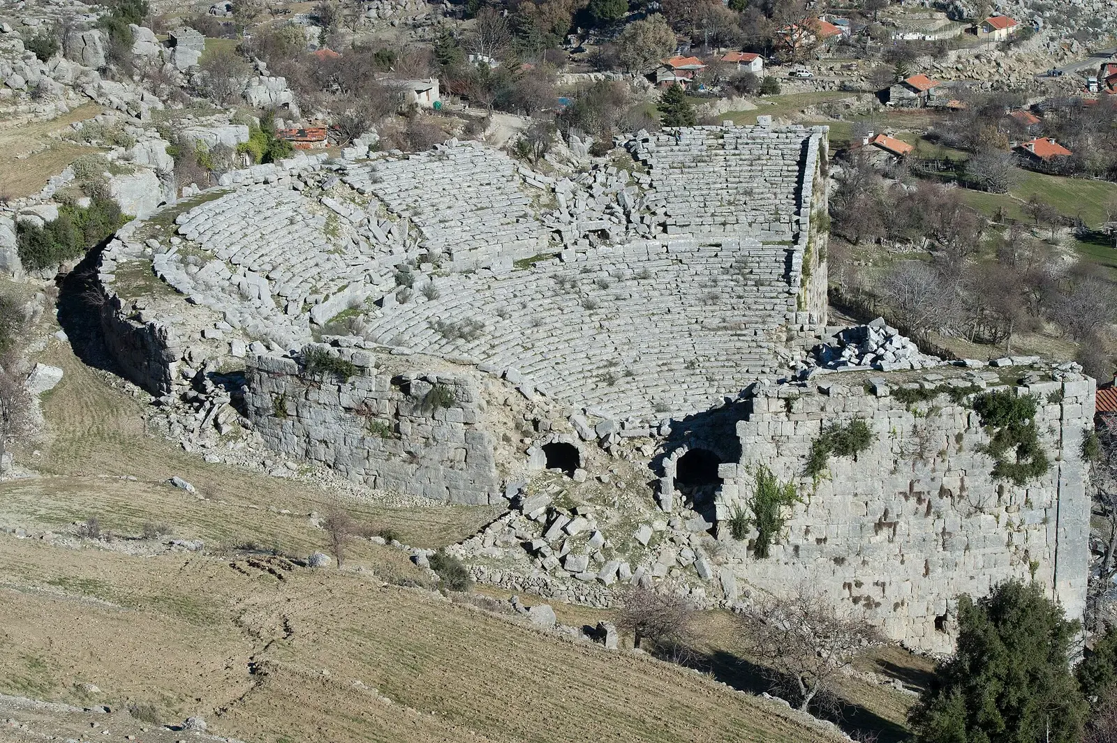 Het theater van Selge van bovenaf met het bergdorp Altınkaya op de achtergrond