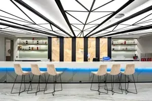 Designbar in Long Beach Alanya met witte barkrukken en moderne verlichting.