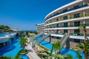 Buitenkant van Long Beach Alanya met hotelgebouw en zwembaden.
