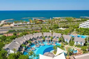 Luchtfoto van zwembaden en villa’s bij Long Beach Alanya met uitzicht op zee.