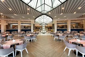 Modern restaurant in Long Beach Alanya met ronde tafels en stijlvol plafond.