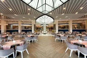 Modern restaurant in Long Beach Alanya met ronde tafels en stijlvol plafond.