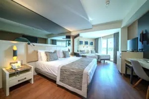 Ruime hotelkamer in Long Beach Alanya met meerdere slaapplaatsen en een moderne inrichting.