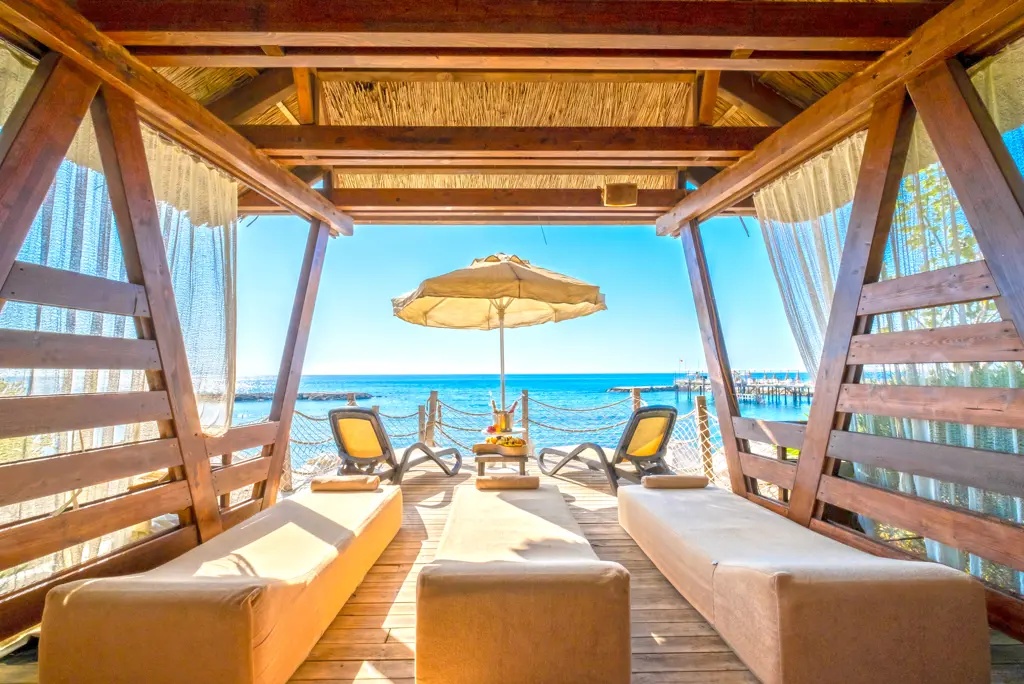 Strandcabana bij Long Beach Alanya met ligbedden en uitzicht op zee.