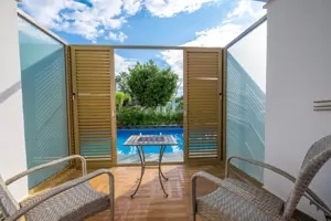 Terras bij Long Beach Alanya met stoelen en een klein privézwembad.