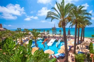 Zwembad van Long Beach Alanya met palmbomen en uitzicht op zee.